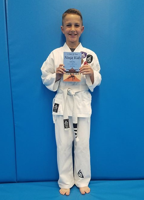 Young ninja holding "A Tale Of Two Ninja Kids" book. Young ninja holding "A Tale Of Two Ninja Kids" book.