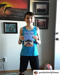 Young ninja holding "A Tale Of Two Ninja Kids" book. Young ninja holding "A Tale Of Two Ninja Kids" book.