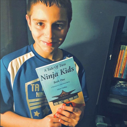 A Tale Of Two Ninja Kids happy reader holding book. A Tale Of Two Ninja Kids happy reader holding book.